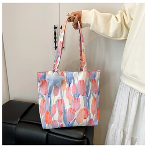 Detail of floral canvas tote bag featuring pink tulip prints and blue star plush charm