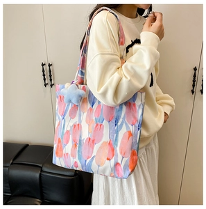 Floral canvas tote bag with tulip prints and star pendant shown on female model shoulder