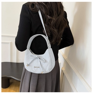 Vue détaillée d'un sac bleu clair avec nœud décoratif et logo métallique JINGPIN chic