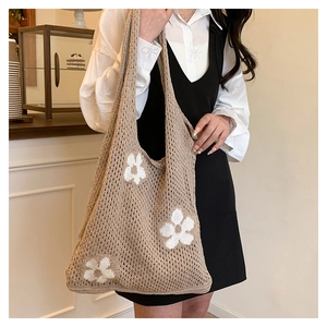Detail of khaki crochet tote bag with white flower knit patterns and cotton texture