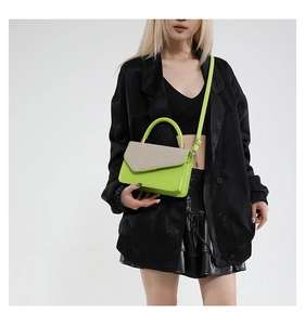 Detail view of neon green and beige fabric patchwork on a minimalist square crossbody bag