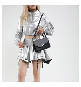 Close-up of black leather handbag paired with a metallic silver Y2K style tracksuit outfit