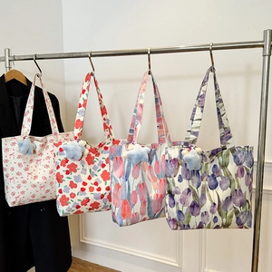 Floral canvas tote bags with rose prints and star pendants hanging on a metal rack