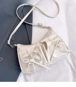 Vue détaillée du sac blanc avec poches à nœuds et finitions métalliques argentées