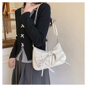 Détail du sac en cuir PU blanc crème avec poches à nœuds coulissants et texture souple