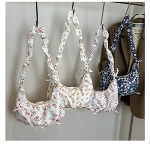 Detailed view of four colorful floral croissant bags with scrunchie style straps