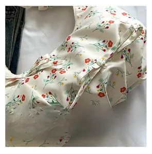 Close-up of floral canvas hobo bag with red flower pattern and ribbon tie detail