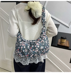 Dettaglio della borsa a mezzaluna floreale con tracolla a nodo indossata da una modella