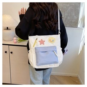 Detail der weiß-blauen Canvas-Tasche mit seitlicher Kordelzugtasche und Stern-Patch