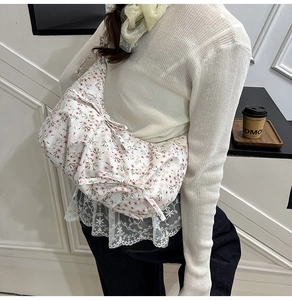 Dettaglio della borsa floreale con decorazione a fiocco e bordo in pizzo delicato