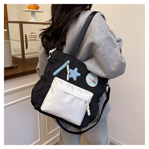 Detail of college style nylon tote bag with star patch and contrasting front pocket