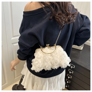 Detail of white 3D floral shell bag with gold handle and chain strap for evening wear
