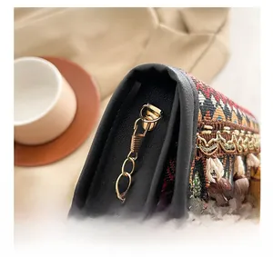 Gros plan sur un sac ethnique avec chaîne dorée et détails de pompons colorés