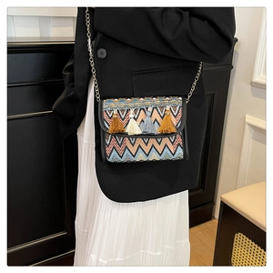 Détail d'un sac bandoulière bohème avec motifs zigzag colorés et accents de glands