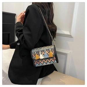 Détail d'un sac bohème avec motifs géométriques colorés et décorations à pompons
