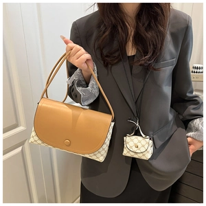 Dettaglio del set borsa a tracolla con patta in pelle marrone e mini ciondolo coordinato
