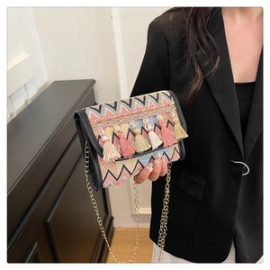 Détail du sac bandoulière tissé géométrique avec glands colorés et chaîne dorée