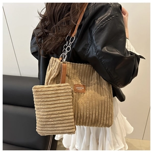 Detail of khaki corduroy tote and pouch set with metal chain strap on female model