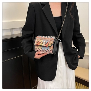 Détail d'un sac bandoulière style ethnique avec glands colorés et bandoulière chaîne
