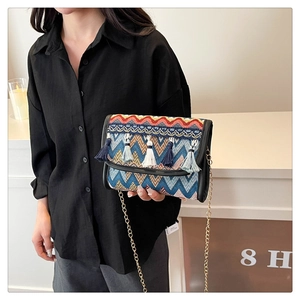 Détail d'un sac bandoulière bohème avec broderies colorées et accents de glands