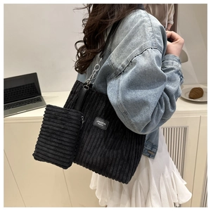 Detail of black corduroy tote bag with small zipper pouch and chain shoulder strap