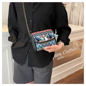 Détail d'un sac bandoulière ethnique tissé avec motifs colorés et élégantes franges
