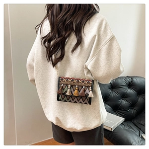 Détail d'un sac bohème montrant des motifs tissés colorés et des pompons vibrants