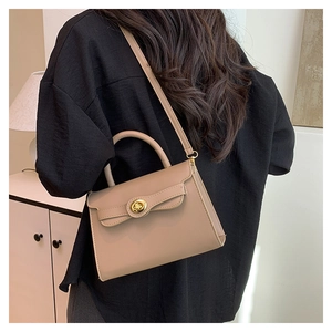 Detail of khaki leather Kelly bag with golden twist lock and adjustable shoulder strap
