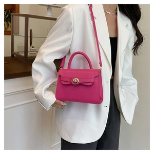 Detail of fuchsia leather Kelly bag with golden twist lock and slim shoulder strap