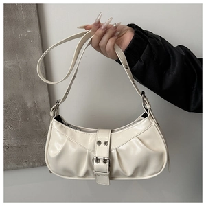Detail of a vintage-style pleated off-white shoulder bag with silver belt buckle accent