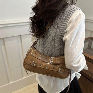 Brown patent leather rivet shoulder bag in retro Y2K style worn by a fashion model