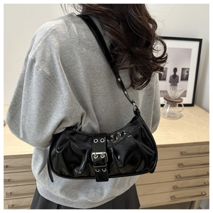 Detail of glossy black patent leather bag with rustic belt buckle and pleated texture