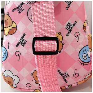 Detail der rosa karierten Kinder-Brusttasche mit verstellbarer Schnalle und Bärenmuster