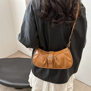 Vintage caramel pleated shoulder bag with decorative buckle shown on a model
