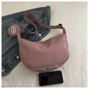 Detail of pink corduroy crescent bag with adjustable strap and mini round coin purse