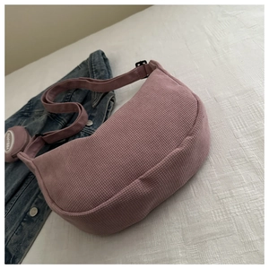 Detailed view of pink waffle fabric crescent bag with adjustable strap and mini round charm