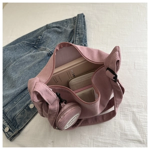 Pink corduroy crossbody tote with spacious interior storage and matching round mini pouch