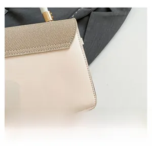 Detail shot of beige flap bag showing woven texture and smooth leather paneling