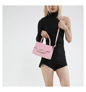 Detail of pink small square bag with woven texture flap and golden buckle on model