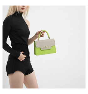 Detail of contrast stitching handbag with neon green leather and beige woven flap texture