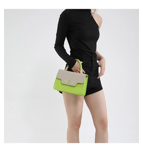 Detail of neon green leather bag with woven texture flap and gold metal lock clasp