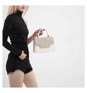 Detail of color-block handbag with textured brown flap and cream leather finish
