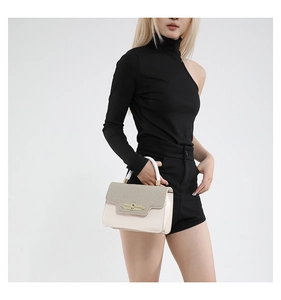 Detail of vintage tote bag featuring woven texture flap and golden metallic lock buckle