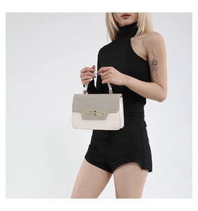 Detail of vintage square crossbody bag featuring mixed-texture fabric and metal twist lock