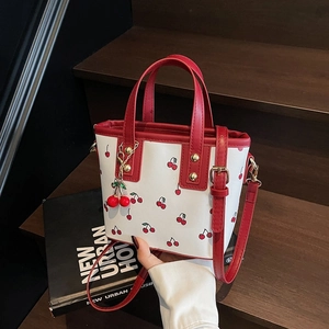 Sac fourre-tout à motif cerises blanc avec anses rouges et pendentif cerise assorti
