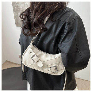 Détail du sac demi-lune blanc crème avec boucles argentées réglables sur le mannequin