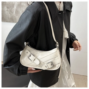 Détail du sac demi-lune blanc brillant avec boucles métalliques et bandoulière chic