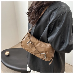 Détail du sac sous l'aisselle camel avec sangles décoratives et boucles argentées