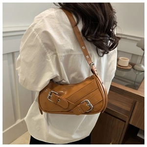 Gros plan du sac sous le bras caramel avec boucles argentées et sangle à œillets