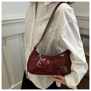 Détail du sac baguette bordeaux en similicuir avec boucles argentées sur modèle